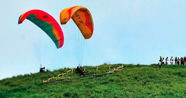 A group of people parachuting on a hill Description automatically generated