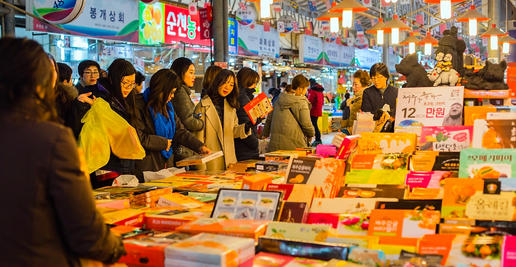 A group of people at a book stand Description automatically generated