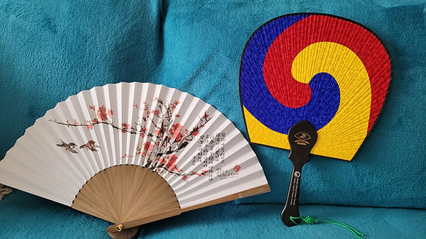 A pair of hand fans on a blue couch Description automatically generated